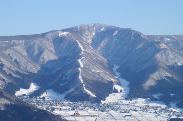 Snow-covered Mount Kenashi, Nozawa Onsen ski runs and the village below